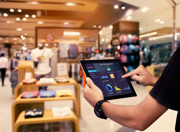 Homem mexendo em um tablet dentro de uma loja de roupa